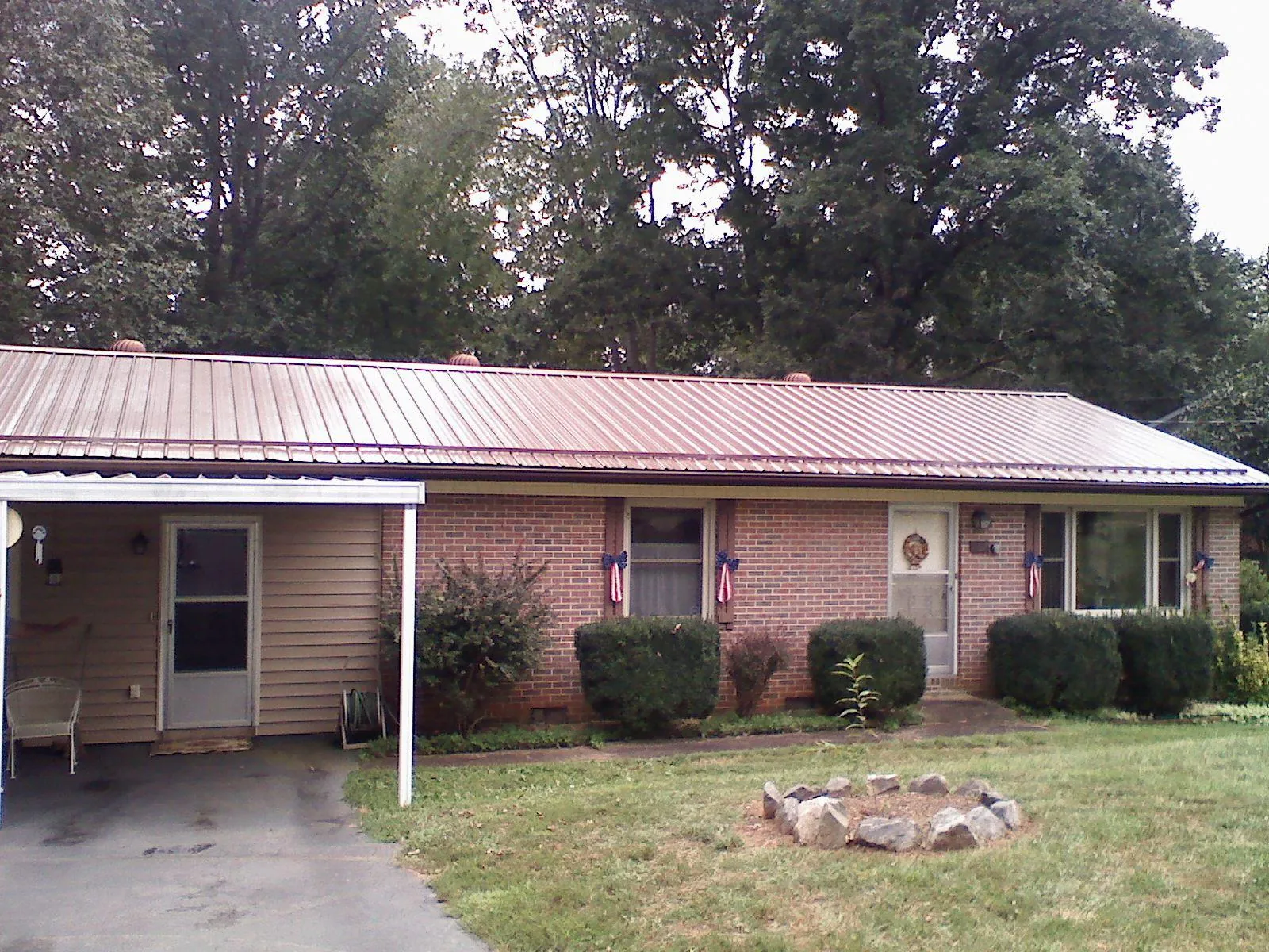 Bronze metal roof and carport on a brick ranch home — Roof Repair work by our crew in Somerset